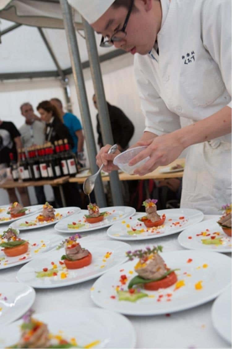 L’assistente di Hiroyuki Kurosu  mentre guarnisce il piatto in concorso